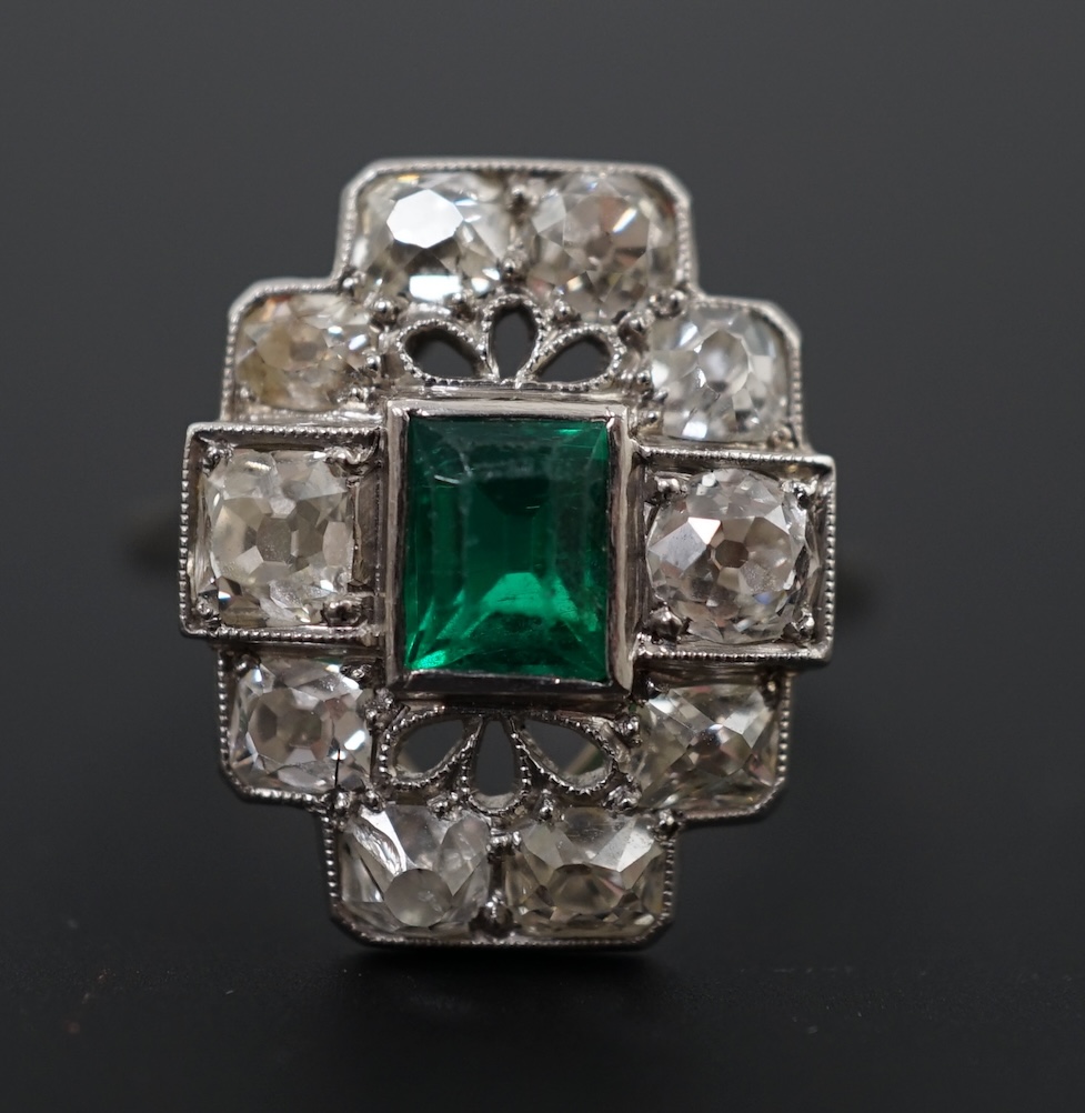 An early to mid 20th century white gold?, emerald and diamond cluster set stepped oval dress ring
